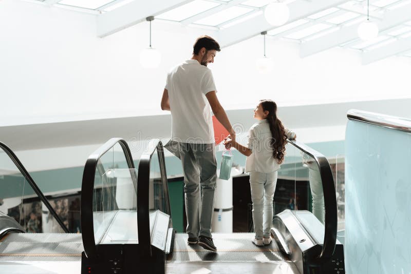 El padre y la hija van abajo en la escalera móvil en centro comercial fotos de archivo El padre y la hija van abajo en la escalera móvil en centro comercial fotos de archivo