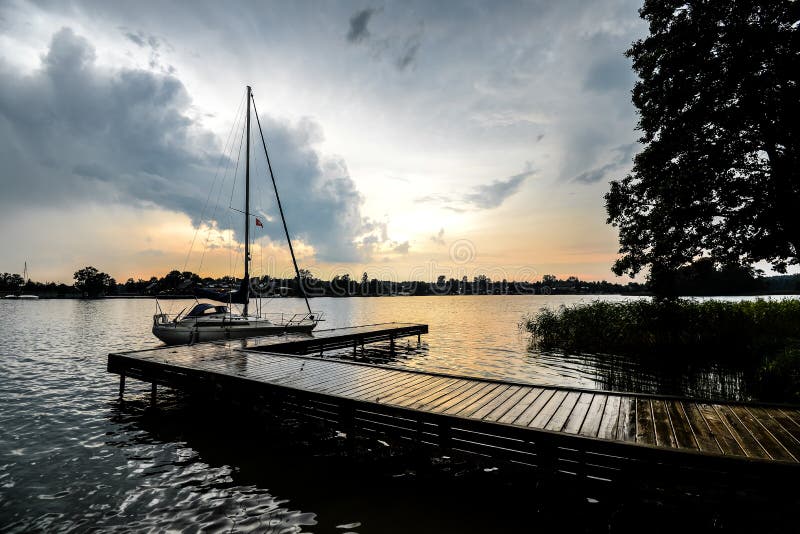 El paisaje hermoso del verano del lago Trakai y poco deporte navegan lago y cielo de la puesta del sol fotografía de archivo libre de regalías El paisaje hermoso del verano del lago Trakai y poco deporte navegan lago y cielo de la puesta del sol fotografía de archivo libre de regalías