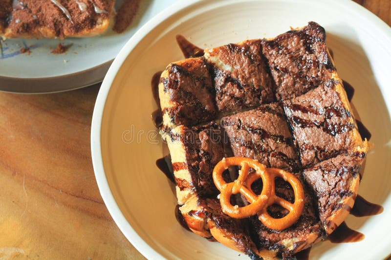 El pan concentrado del chocolate, remató con la salsa de chocolate y adornado con las galletas sirvió en una placa fotos de archivo El pan concentrado del chocolate, remató con la salsa de chocolate y adornado con las galletas sirvió en una placa fotos de archivo