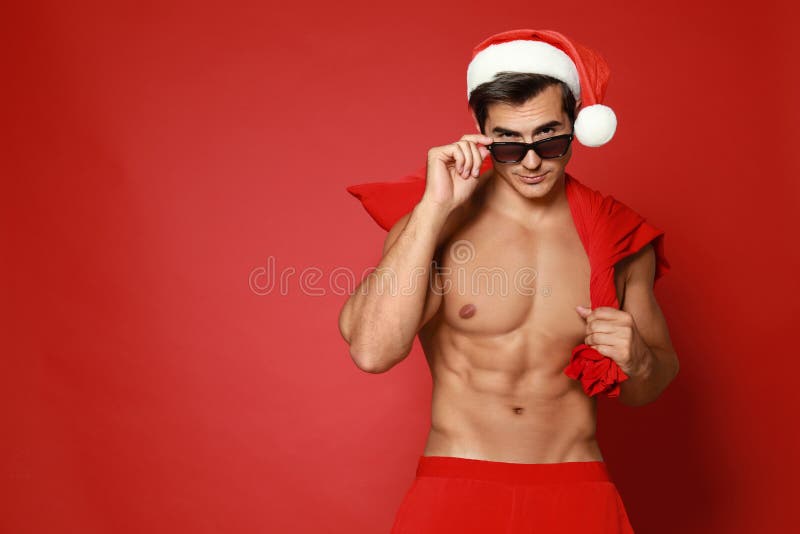 El Papá Noel sexy sin camisa con fondo rojo foto de archivo libre de regalías El Papá Noel sexy sin camisa con fondo rojo foto de archivo libre de regalías