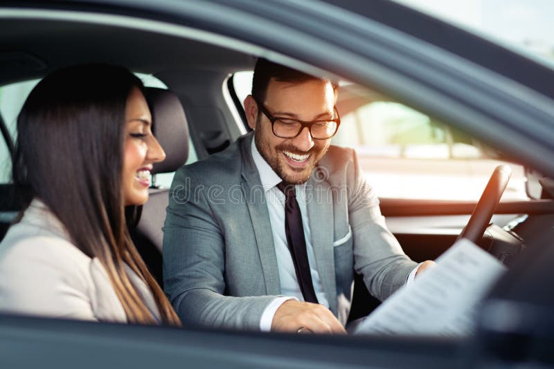 El par hermoso es que habla y sonriente mientras que se sienta en su nuevo coche imagenes de archivo El par hermoso es que habla y sonriente mientras que se sienta en su nuevo coche imagenes de archivo