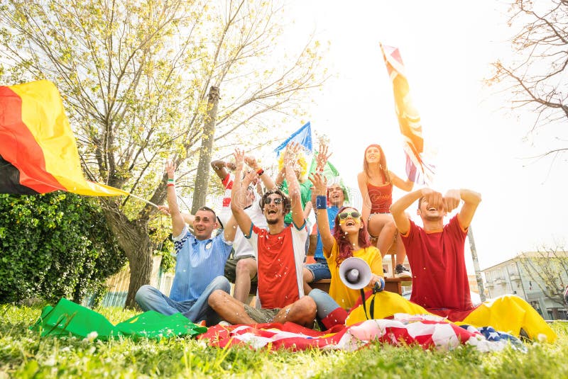 El partidario joven del fútbol aviva animar con las banderas internacionales imagenes de archivo El partidario joven del fútbol aviva animar con las banderas internacionales imagenes de archivo