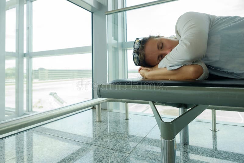 El pasajero cansado es el dormir o en terminal de aeropuerto y para llegada del aeroplano que espera fotografía de archivo libre de regalías El pasajero cansado es el dormir o en terminal de aeropuerto y para llegada del aeroplano que espera fotografía de archivo libre de regalías