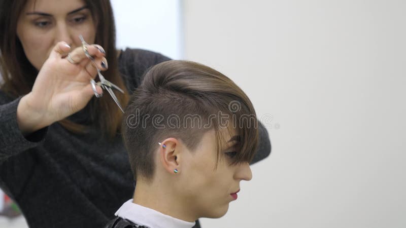 El peluquero del ` s de la mujer hace diseñar su pelo en el pelo corto