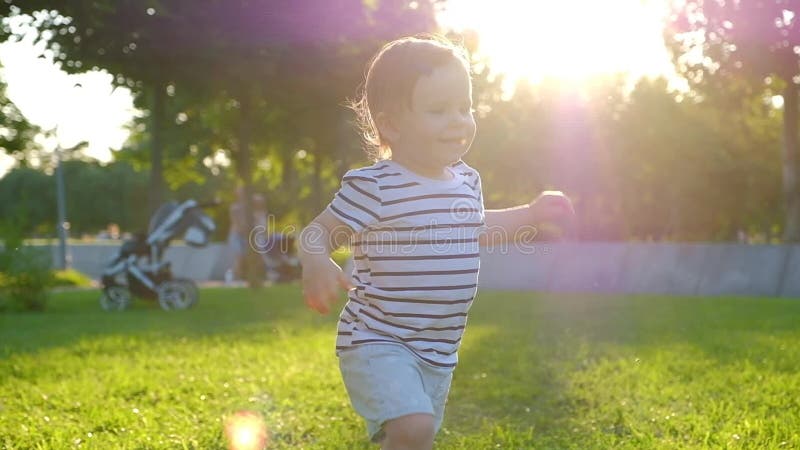 El pequeño bebé lindo camina por la hierba metrajes