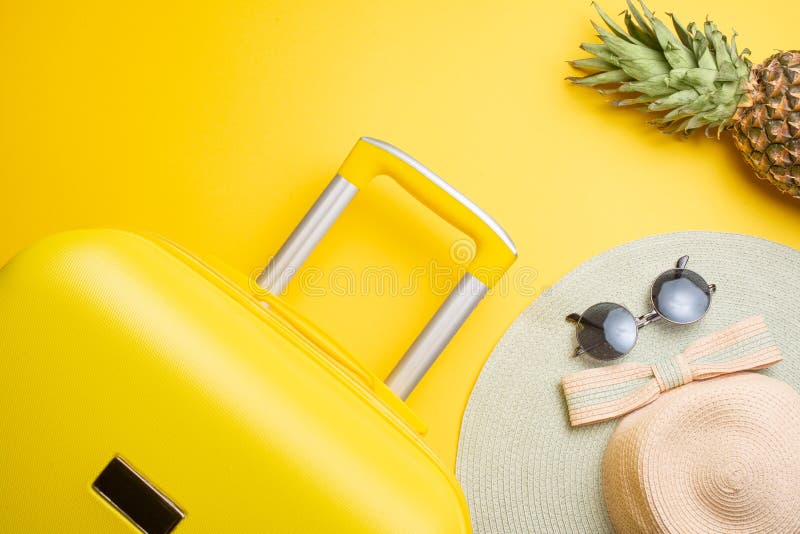 El plano pone una maleta amarilla con los accesorios y la piña para relajarse en un fondo amarillo concepto de viaje, resto y imagenes de archivo El plano pone una maleta amarilla con los accesorios y la piña para relajarse en un fondo amarillo concepto de viaje, resto y imagenes de archivo