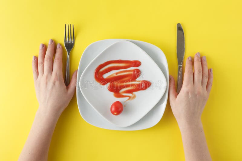 El plato blanco con la salsa de tomate formó, las manos con el cuchillo y bifurcación fotos de archivo