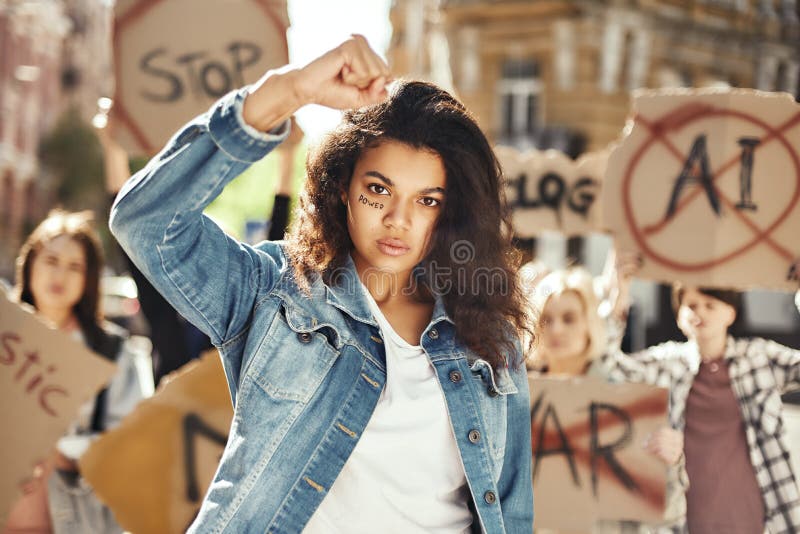 El poder de una mujer joven y fuerte está protestando por el empoderamiento de la mujer con un grupo de mujeres activistas mientra fotos de archivo libres de regalías