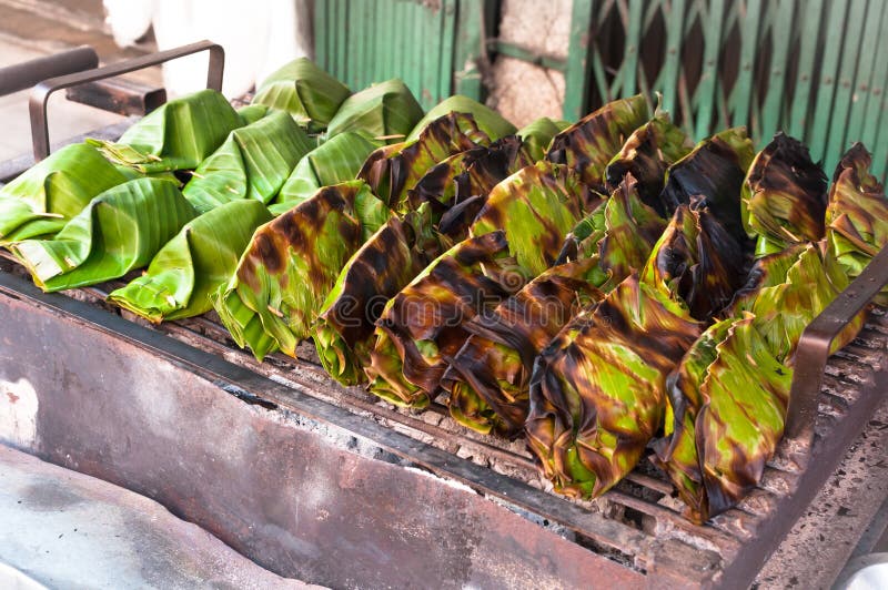El postre de Tailandia envuelto en plátano se va, las natillas de la leche de coco con el dulce del coco, arroz pegajoso asado a imágenes de archivo libres de regalías