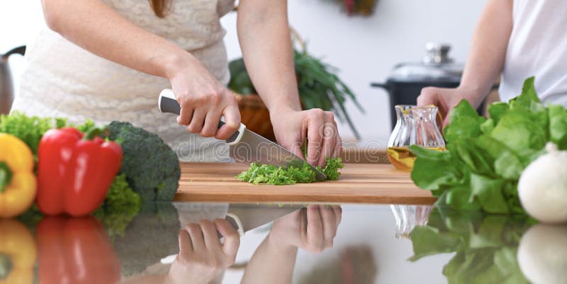 El primer de cuatro manos humanas está cocinando en una cocina Amigos que se divierten mientras que prepara la ensalada fresca ve fotos de archivo El primer de cuatro manos humanas está cocinando en una cocina Amigos que se divierten mientras que prepara la ensalada fresca ve fotos de archivo