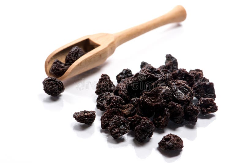 El primer de la pila se secó, las cerezas crudas en una cuchara de madera en blanco foto de archivo libre de regalías