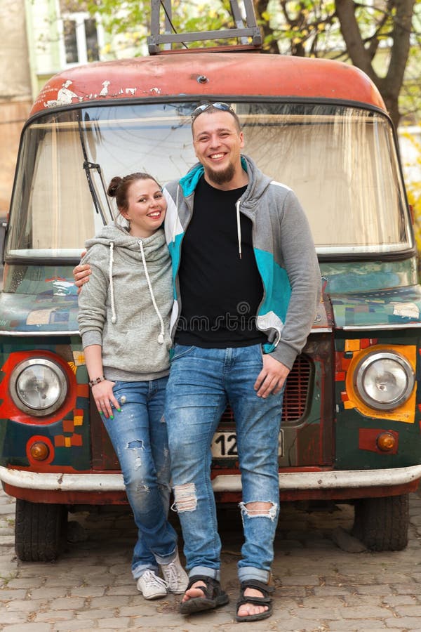 El primer de los pares de la familia acerca a la furgoneta vieja del hippie del coche o del gitano del paintyng colorido fotografía de archivo libre de regalías El primer de los pares de la familia acerca a la furgoneta vieja del hippie del coche o del gitano del paintyng colorido fotografía de archivo libre de regalías