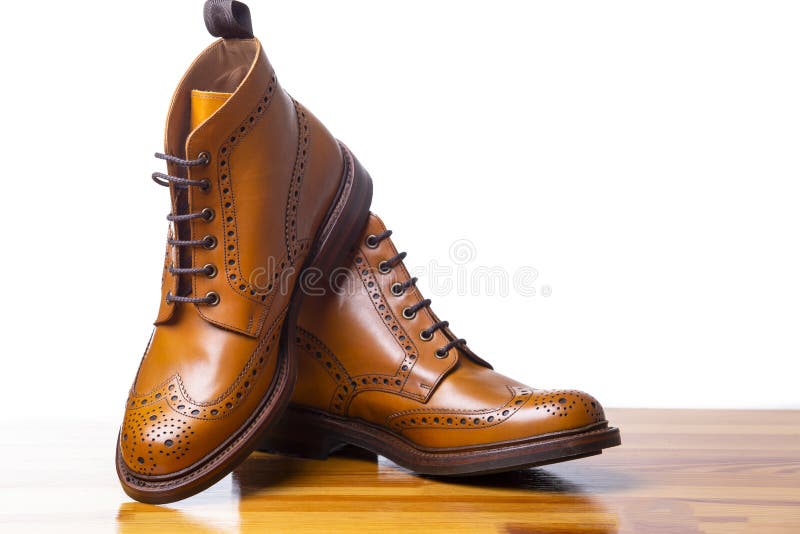 El primer de pares del alto ` s de los hombres bronceó botas de las abarcas imagen de archivo libre de regalías El primer de pares del alto ` s de los hombres bronceó botas de las abarcas imagen de archivo libre de regalías