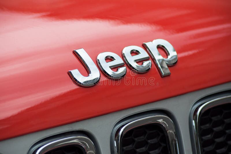 El primer del logotipo del jeep en coche delantero anaranjado parqueó en la calle fotografía de archivo libre de regalías El primer del logotipo del jeep en coche delantero anaranjado parqueó en la calle fotografía de archivo libre de regalías