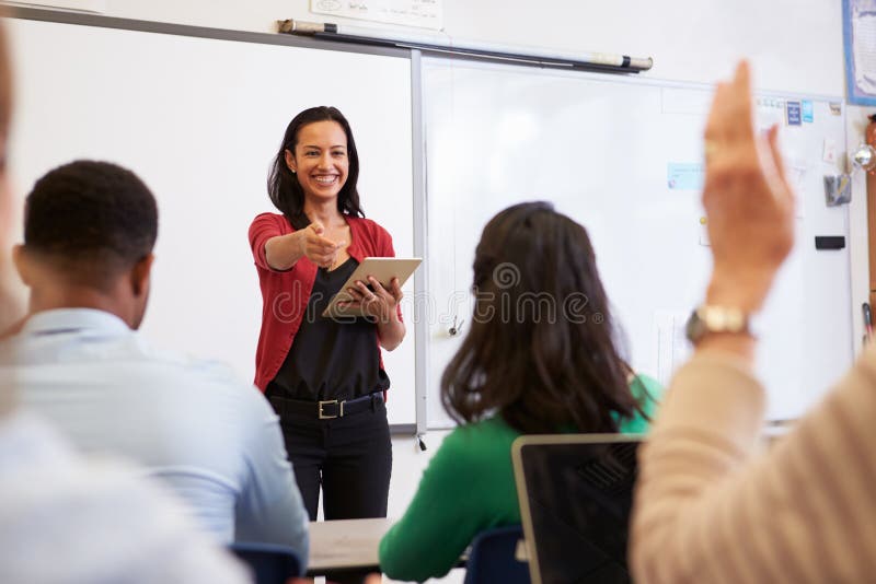 El profesor con la tableta y los estudiantes en una enseñanza para adultos clasifican El profesor con la tableta y los estudiantes en una enseñanza para adultos clasifican