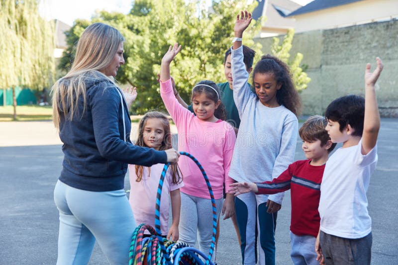 El profesor de deportes distribuye neumáticos a los niños imágenes de archivo libres de regalías