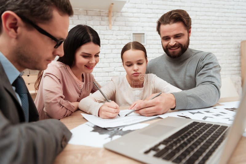 A men sits with his daughter at the table and passes the test. The psychologist is looking at the girl and who is taking the test with dad. A men sits with his daughter at the table and passes the test. The psychologist is looking at the girl and who is taking the test with dad.