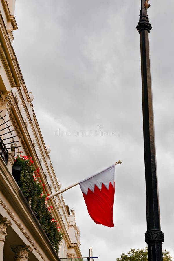 El reino de la bandera de Bahrein que agita del balcón de la embajada en la opinión exterior de Londres imagen de archivo El reino de la bandera de Bahrein que agita del balcón de la embajada en la opinión exterior de Londres imagen de archivo