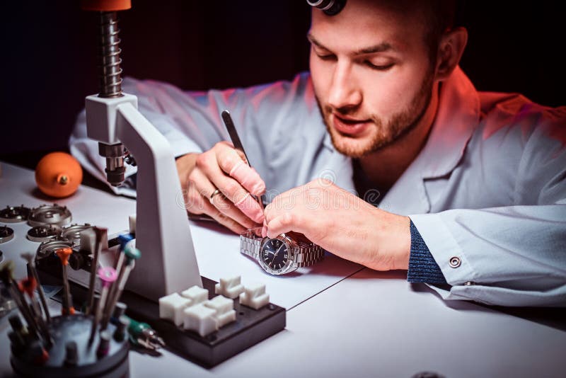 El relojero de Expirienced está haciendo el grabado para el reloj de los custmer en su taller fotos de archivo libres de regalías El relojero de Expirienced está haciendo el grabado para el reloj de los custmer en su taller fotos de archivo libres de regalías