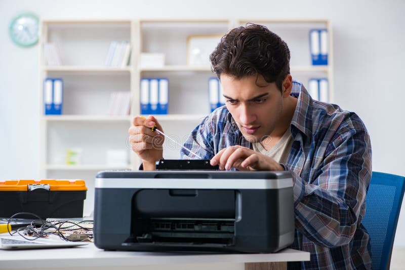 Hardware repairman repairing broken printer fax machine. Hardware repairman repairing broken printer fax machine