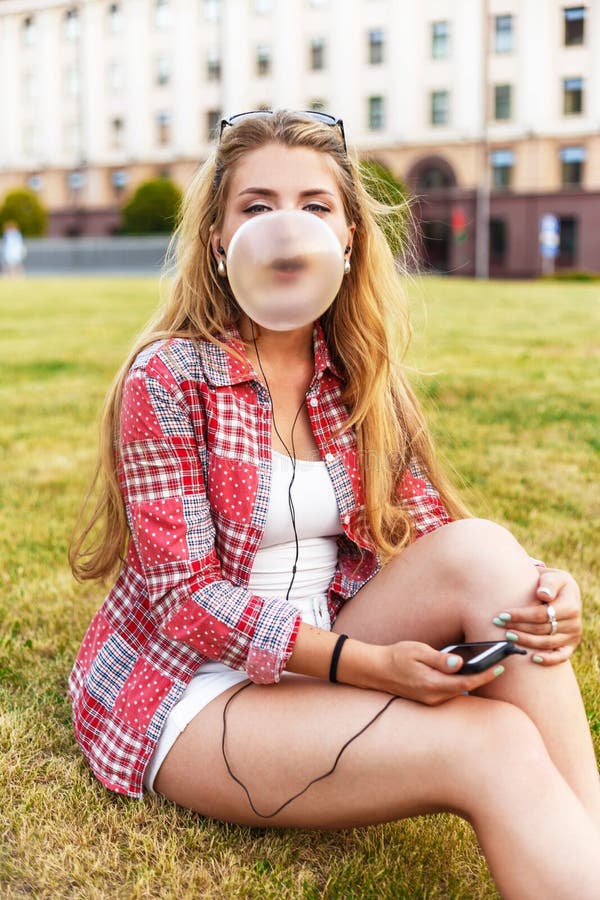 El retrato al aire libre de la forma de vida de la burbuja que sopla de la chica joven bonita en la ciudad, sentándose en la hier imagen de archivo libre de regalías El retrato al aire libre de la forma de vida de la burbuja que sopla de la chica joven bonita en la ciudad, sentándose en la hier imagen de archivo libre de regalías
