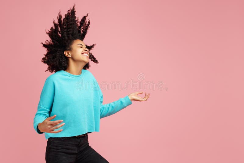 El retrato de la mujer joven afroamericana emocionada con sonrisa brillante vestida en ropa casual baila con la guitarra invisibl fotografía de archivo