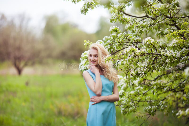 El retrato de la mujer preciosa joven en primavera florece fotografía de archivo El retrato de la mujer preciosa joven en primavera florece fotografía de archivo