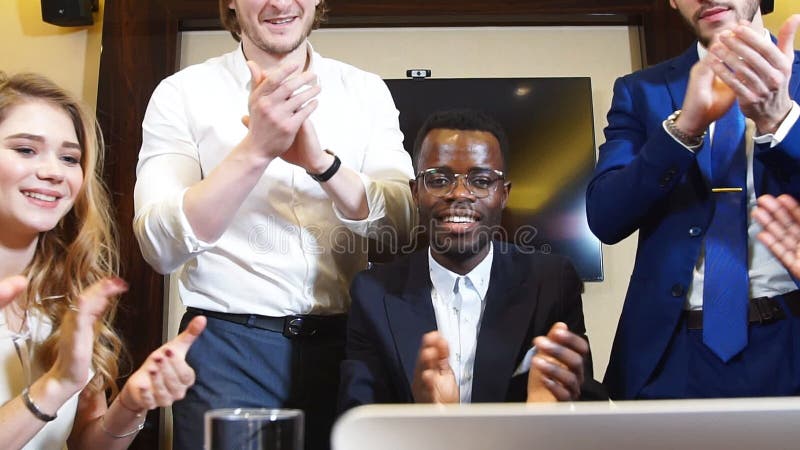 El retrato de los hombres de negocios felices del grupo mira a la cámara y aplaude su éxito empresarial