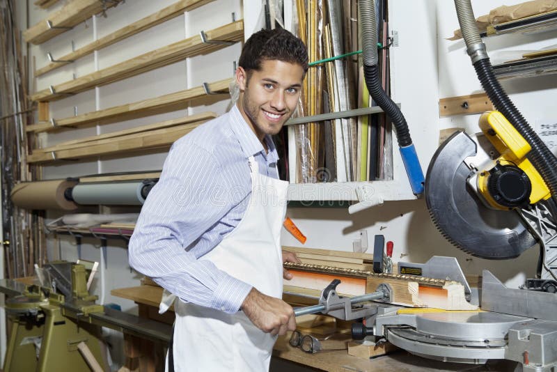 El retrato de una circular que hacía una pausa del artesano joven feliz vio la maquinaria fotografía de archivo libre de regalías El retrato de una circular que hacía una pausa del artesano joven feliz vio la maquinaria fotografía de archivo libre de regalías