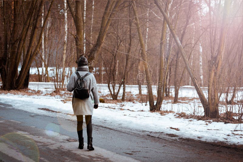 El retrato de una muchacha hermosa feliz con el pelo marrón en el bosque del invierno se vistió en un estilo del inconformista, f imagen de archivo El retrato de una muchacha hermosa feliz con el pelo marrón en el bosque del invierno se vistió en un estilo del inconformista, f imagen de archivo