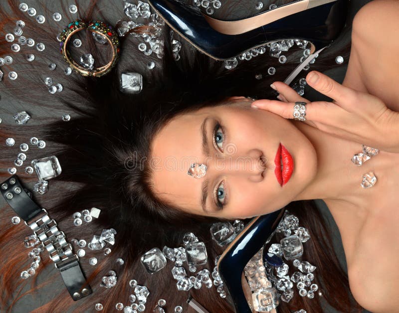 El retrato de una muchacha morena lujosa miente en un placer de la joyer?a de los diamantes, accesorios de lujo fotos de archivo El retrato de una muchacha morena lujosa miente en un placer de la joyer?a de los diamantes, accesorios de lujo fotos de archivo