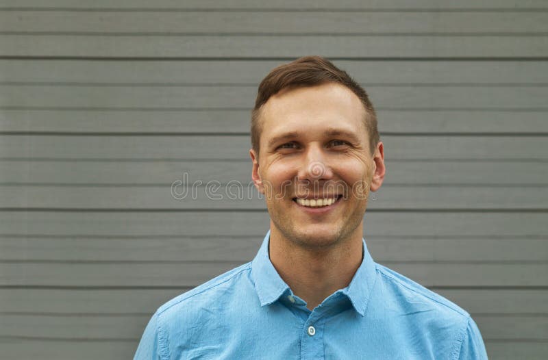 El retrato del freelancer joven está sonriendo en fondo gris fotografía de archivo El retrato del freelancer joven está sonriendo en fondo gris fotografía de archivo