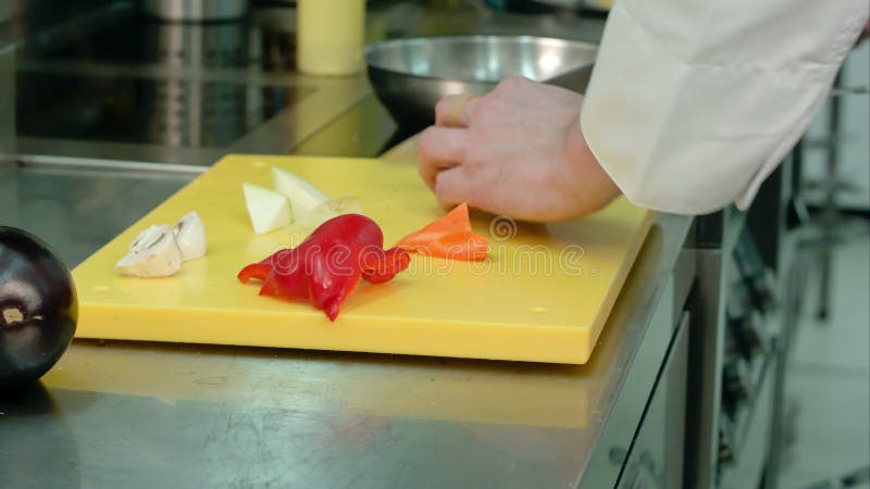 El ` s del cocinero da cortar la pimienta dulce roja