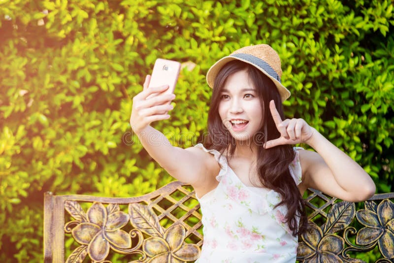 El smartphone del uso de la mujer de Asia toma la foto fotografía de archivo El smartphone del uso de la mujer de Asia toma la foto fotografía de archivo