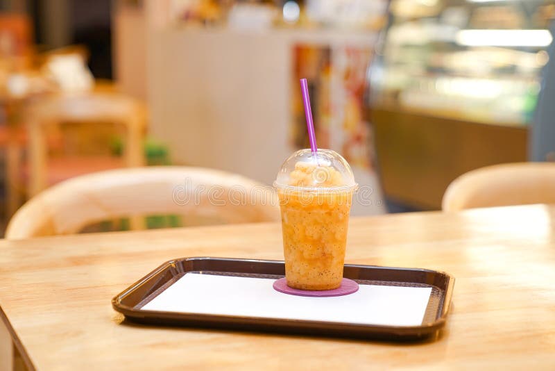 El smoothie de la fruta de la pasión del plástico se lleva la taza en el restaurante imágenes de archivo libres de regalías El smoothie de la fruta de la pasión del plástico se lleva la taza en el restaurante imágenes de archivo libres de regalías