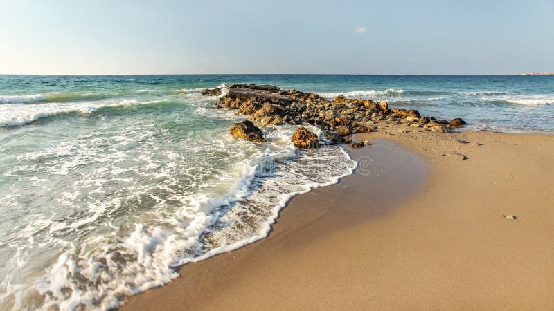 El sol de la tarde brilla en la playa salvaje, algunas pequeñas ondas que golpean pequeñas rocas en el fondo, espacio limpio vací fotos de archivo libres de regalías El sol de la tarde brilla en la playa salvaje, algunas pequeñas ondas que golpean pequeñas rocas en el fondo, espacio limpio vací fotos de archivo libres de regalías
