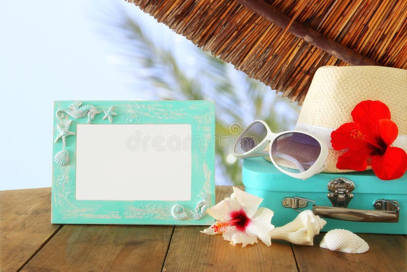 El sombrero de Fedora, gafas de sol, hibisco tropical florece al lado de marco en blanco sobre fondo de madera del paisaje de la imágenes de archivo libres de regalías El sombrero de Fedora, gafas de sol, hibisco tropical florece al lado de marco en blanco sobre fondo de madera del paisaje de la imágenes de archivo libres de regalías