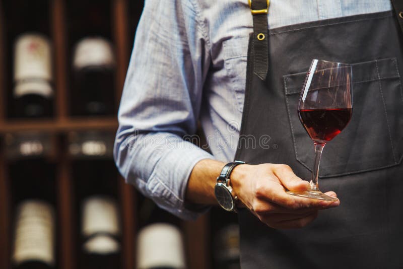 El sommelier masculino se considera bokal con el vino rojo disponible fotografía de archivo El sommelier masculino se considera bokal con el vino rojo disponible fotografía de archivo