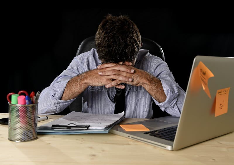 El stress laboral sufridor del hombre de negocios cansado perdió ocupado preocupante en oficina tarde en la noche con el ordenado
