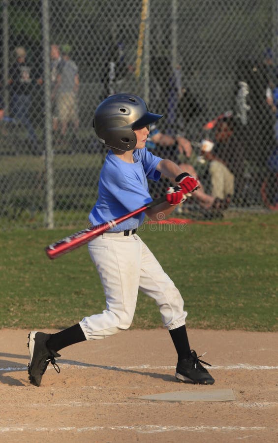 A Young Little League Batter Swings at a Pitch. A Young Little League Batter Swings at a Pitch