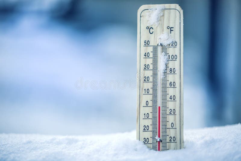 El termómetro en nieve muestra las bajas temperaturas - cero Bajas temperaturas los grados Celsius y Fahrenheit Tiempo frío del i