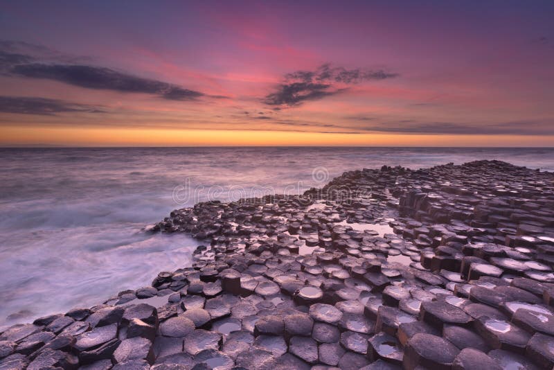 El terraplén del gigante en Irlanda del Norte en la puesta del sol imagenes de archivo El terraplén del gigante en Irlanda del Norte en la puesta del sol imagenes de archivo