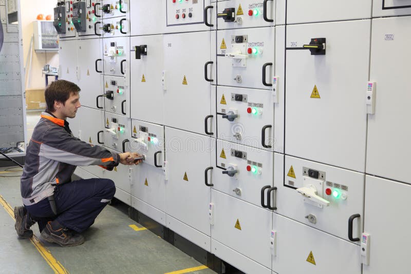 El trabajador hace mantenimiento del equipo eléctrico imágenes de archivo libres de regalías El trabajador hace mantenimiento del equipo eléctrico imágenes de archivo libres de regalías