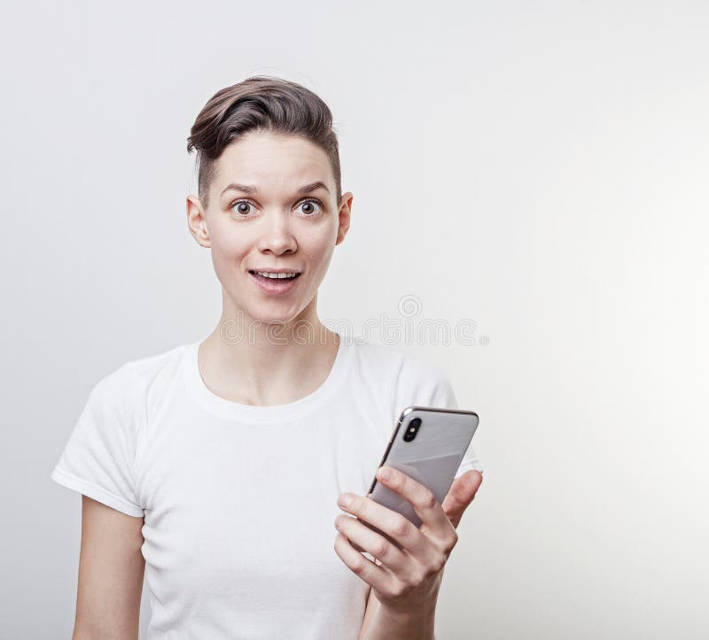 El triunfo o victoria de celebración, triunfo de la mujer milenaria divertida feliz, sosteniendo un teléfono Muchacha emocionada imagenes de archivo El triunfo o victoria de celebración, triunfo de la mujer milenaria divertida feliz, sosteniendo un teléfono Muchacha emocionada imagenes de archivo