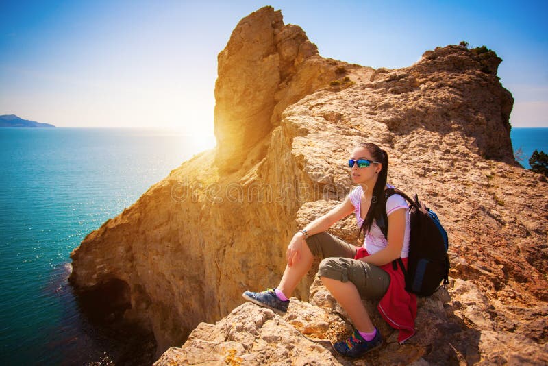 El turista cansado de la mujer está descansando sobre el top de una montaña foto de archivo libre de regalías El turista cansado de la mujer está descansando sobre el top de una montaña foto de archivo libre de regalías