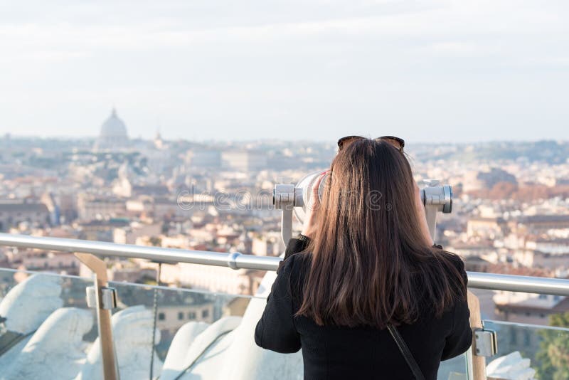 El turista de la mujer está mirando a través de los prismáticos en la ciudad Roma imagenes de archivo El turista de la mujer está mirando a través de los prismáticos en la ciudad Roma imagenes de archivo