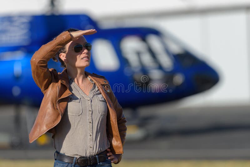 El turista femenino aguarda el helicóptero de la llegada fotografía de archivo libre de regalías El turista femenino aguarda el helicóptero de la llegada fotografía de archivo libre de regalías