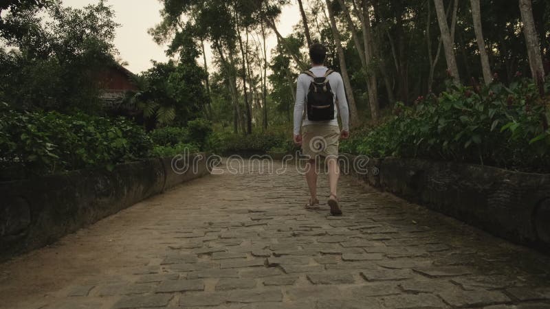 El turista masculino camina por el jardín