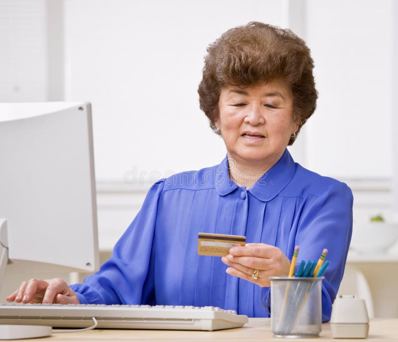 El usar de la mujer de la tarjeta de crédito hacer compras en línea imagen de archivo El usar de la mujer de la tarjeta de crédito hacer compras en línea imagen de archivo