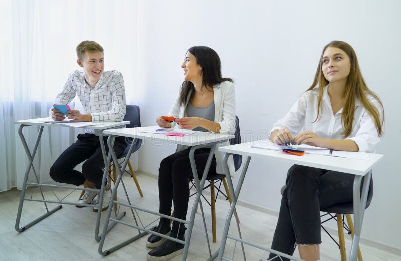 El varón y los estudiantes sonrientes positivos practican trabajo en equipo y realizan capacidades de comunicación imágenes de archivo libres de regalías El varón y los estudiantes sonrientes positivos practican trabajo en equipo y realizan capacidades de comunicación imágenes de archivo libres de regalías